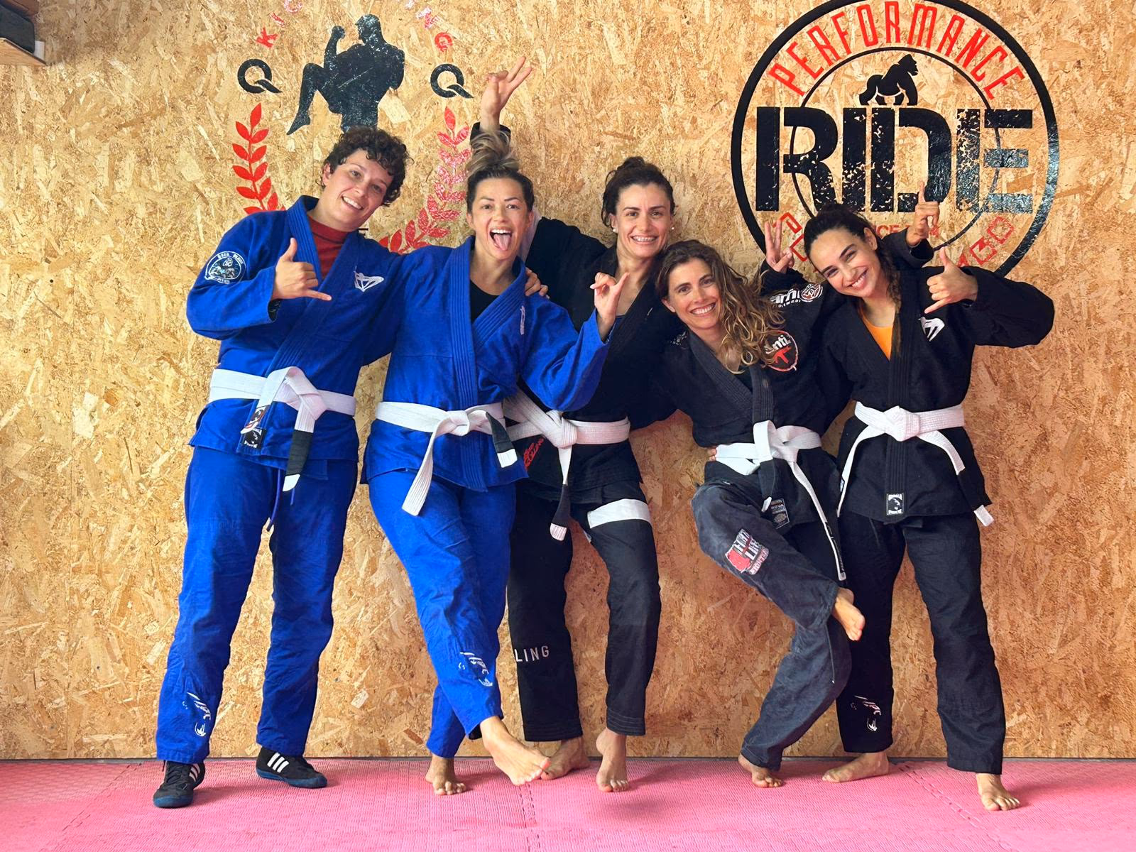 Alumnas de Jiu Jitsu de Powerjambo haciendo el saludo shaka en el tatami